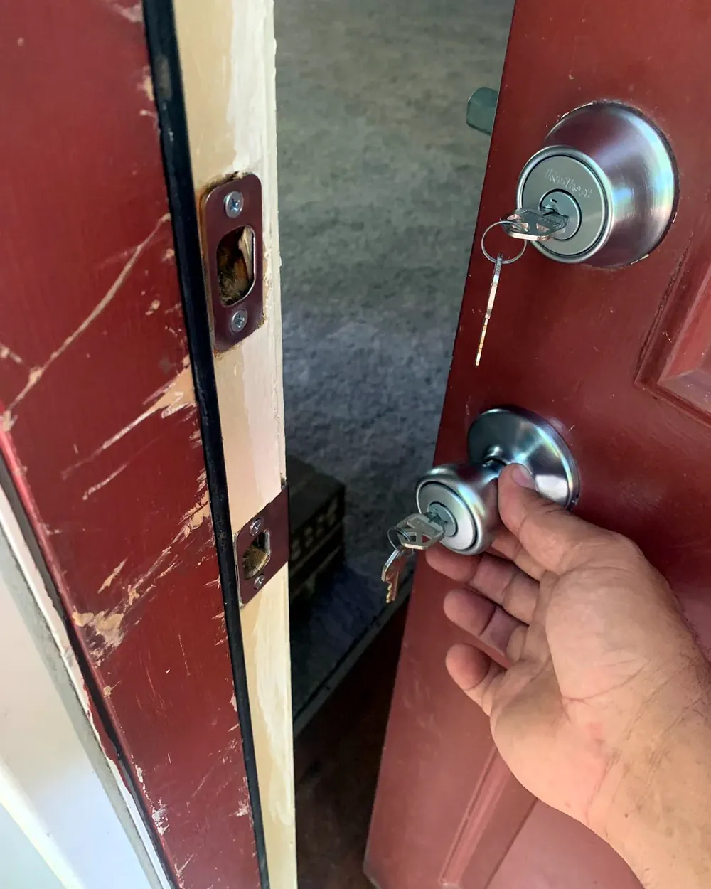 Cerrajero abriendo la puerta de una casa con las llaves nuevas en la cerradura