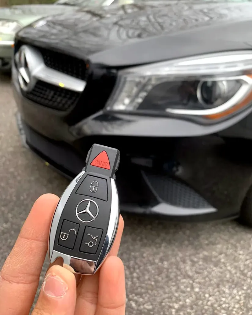 New Mercedes-Benz smart key held in front of a black Mercedes in Nassau County, NY