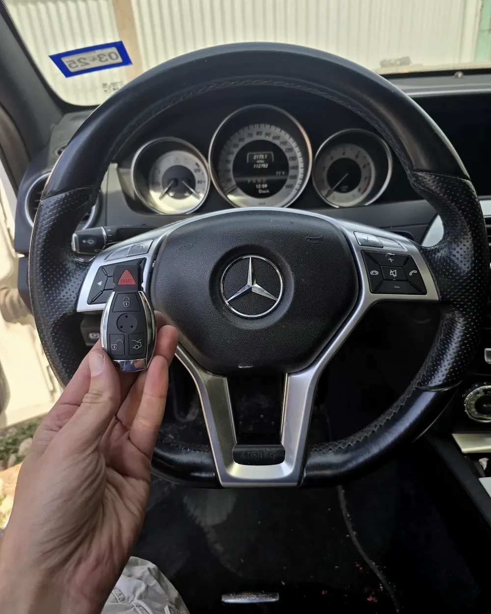 New Mercedes-Benz smart key held at the steering wheel by a locksmith serving Rockville Centre, NY