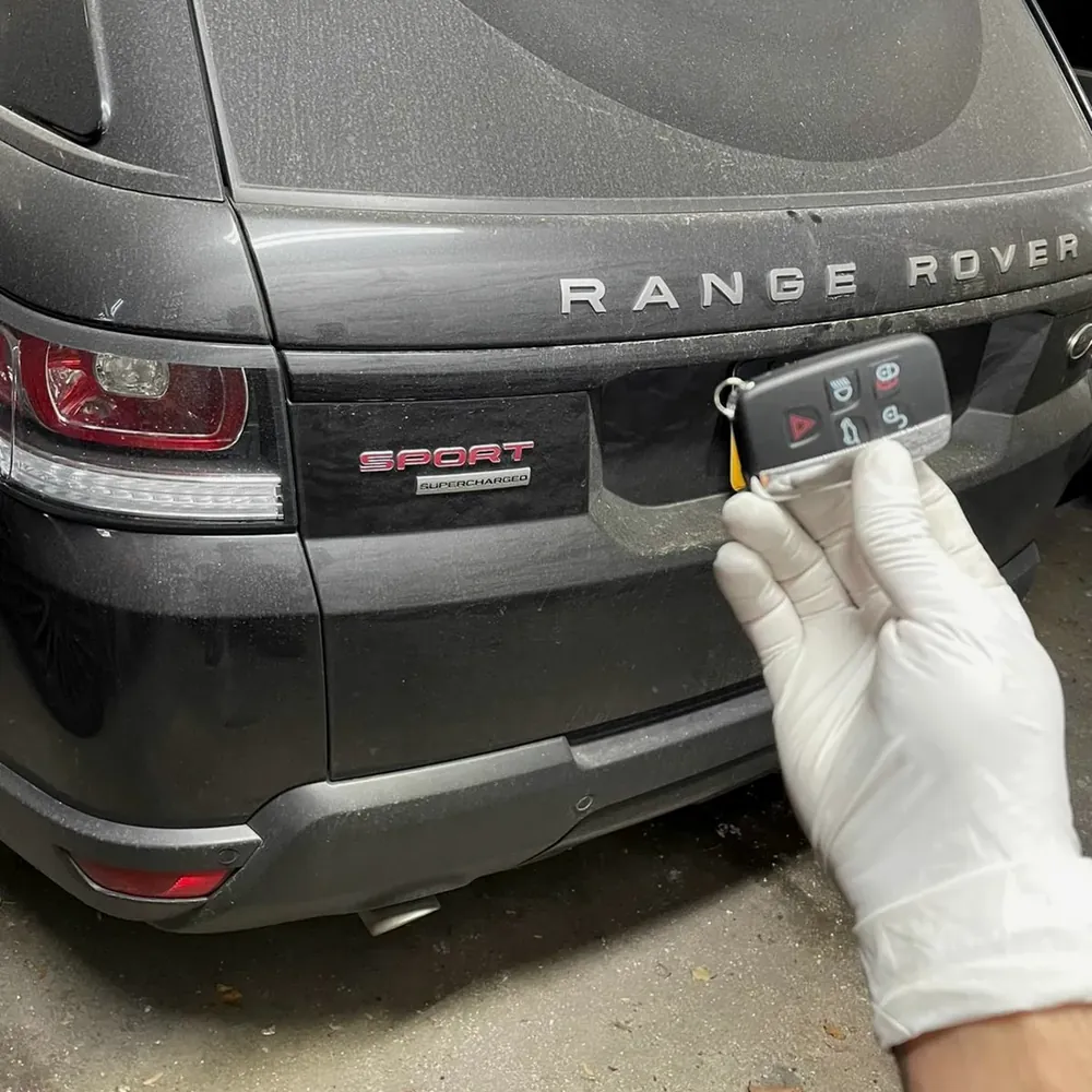 New Range Rover Sport smart key held behind the car