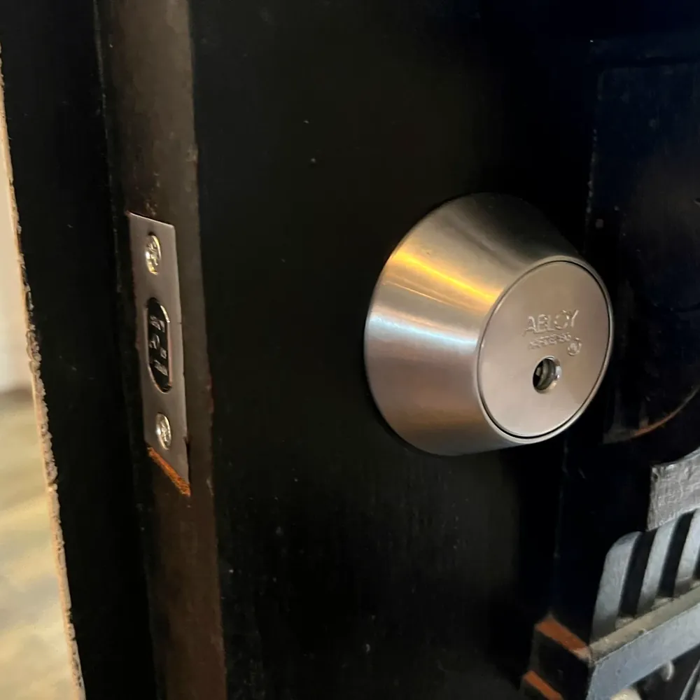 Newly installed deadbolt on a home door, with the bolt and door edge visible